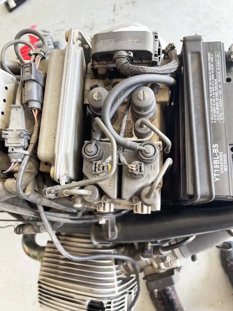 BMW R1150RT engine bay with fairings removed showing ABS brake lines and wiring harness